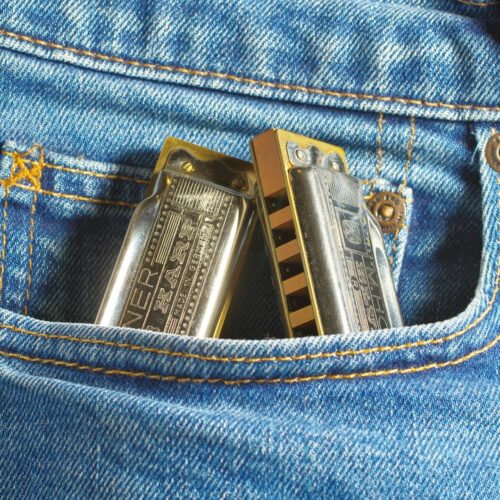 a pair of harmonicas sticking out of the back pocket of a pair of jeans