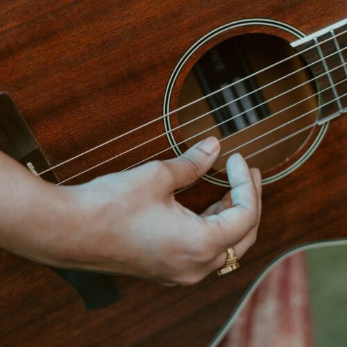 a person holding a guitar in their hand