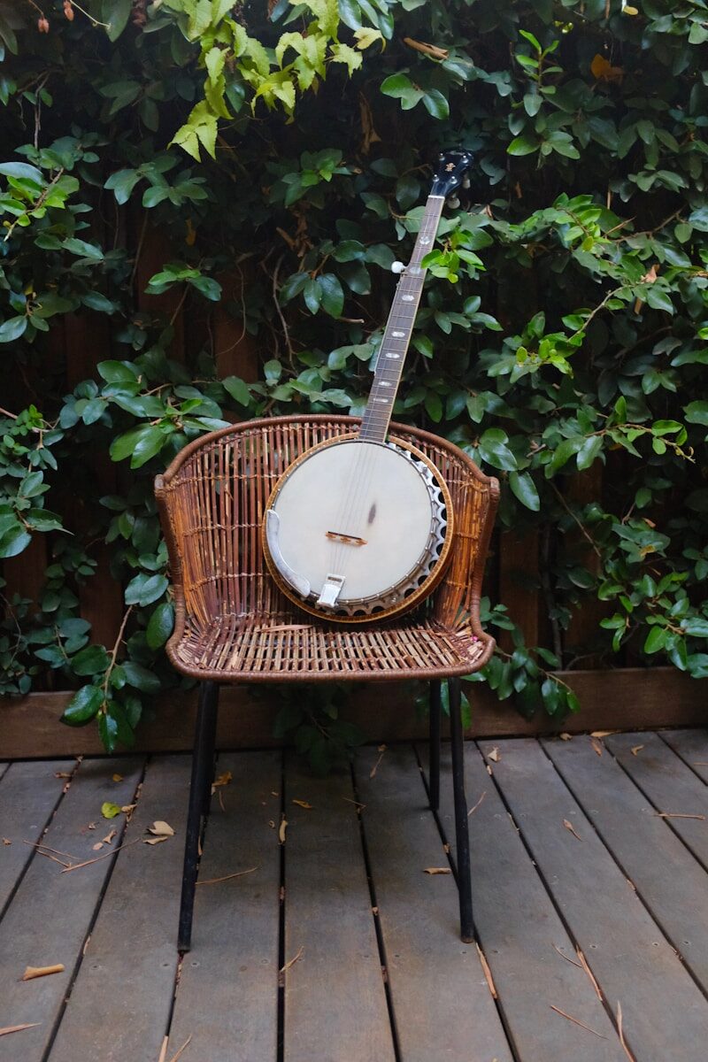 Photo by Chen Mizrach shallow focus photo banjo on brown wicker chair